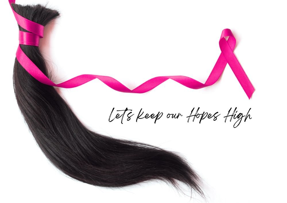 Cancer awareness concept: a ponytail tied with a pink ribbon and the line Let's keep our hopes high
